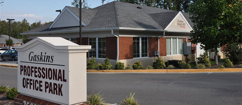 Exterior shot of the surgery center building and Gaskins Professional Office Park signage